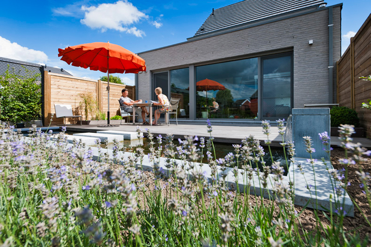 Terras met vijver in tuin van hedendaagse woning