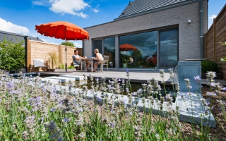 Terras met vijver in tuin van hedendaagse woning